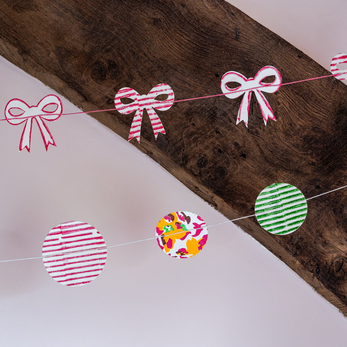Decorative paper garland with bows and circles on a wooden surface