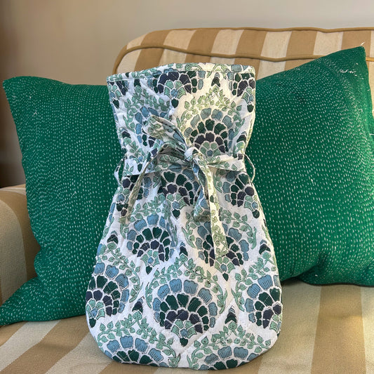 Patterned hot water bottle on a striped couch with green pillows