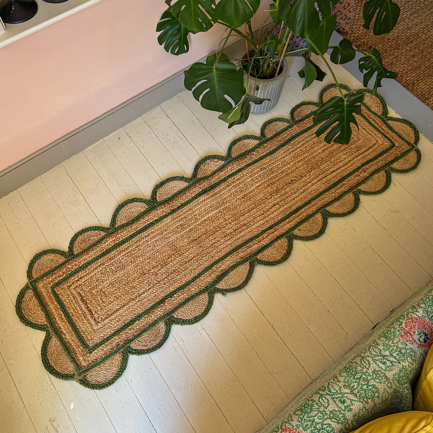 Decorative doormat with scalloped edge on a wooden floor