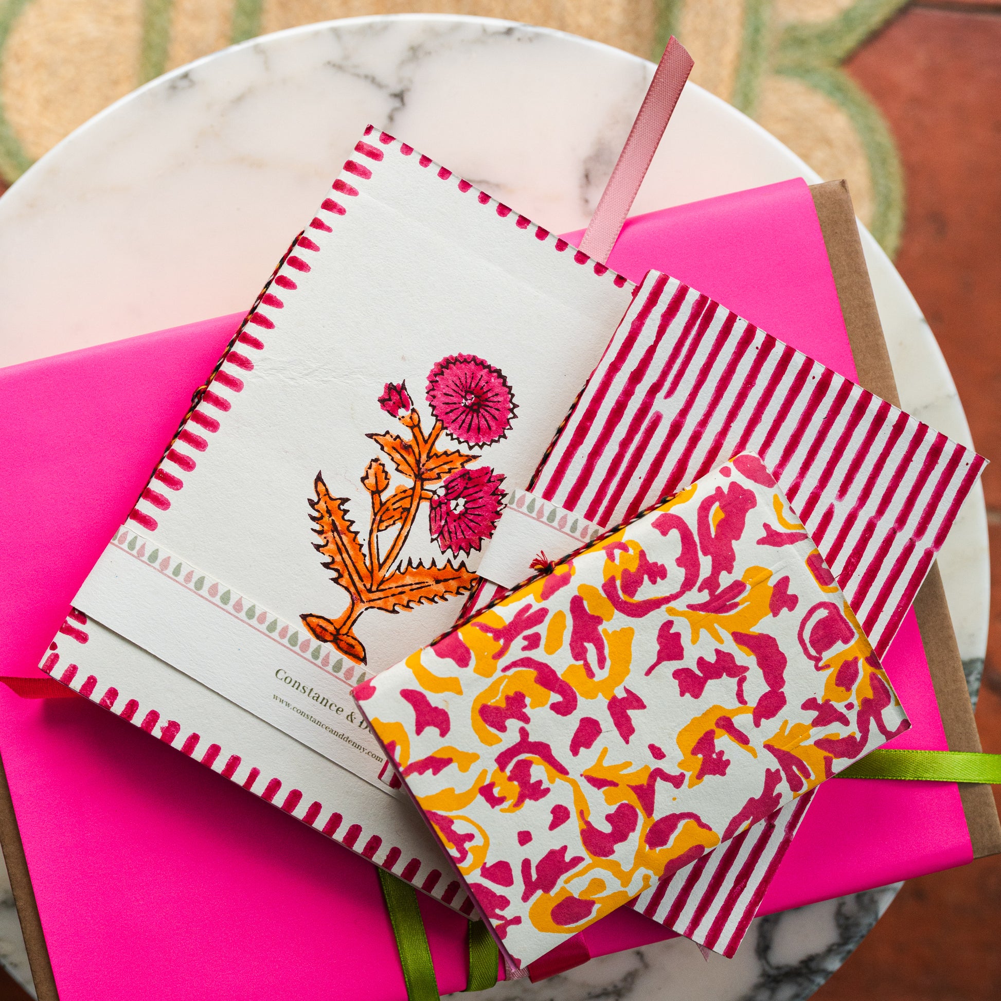 Decorative greeting cards with floral designs on a pink surface