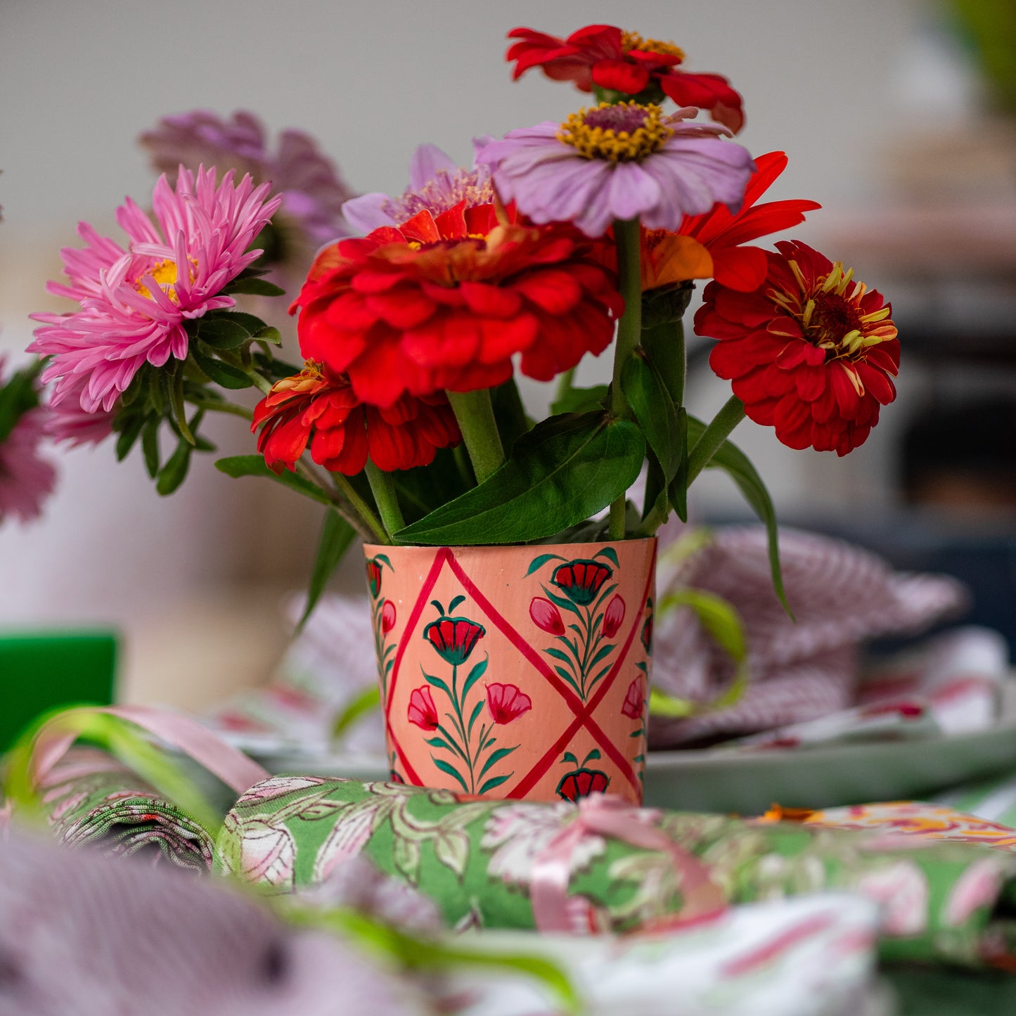 Colorful flowers in a decorative vase on a patterned tablecloth