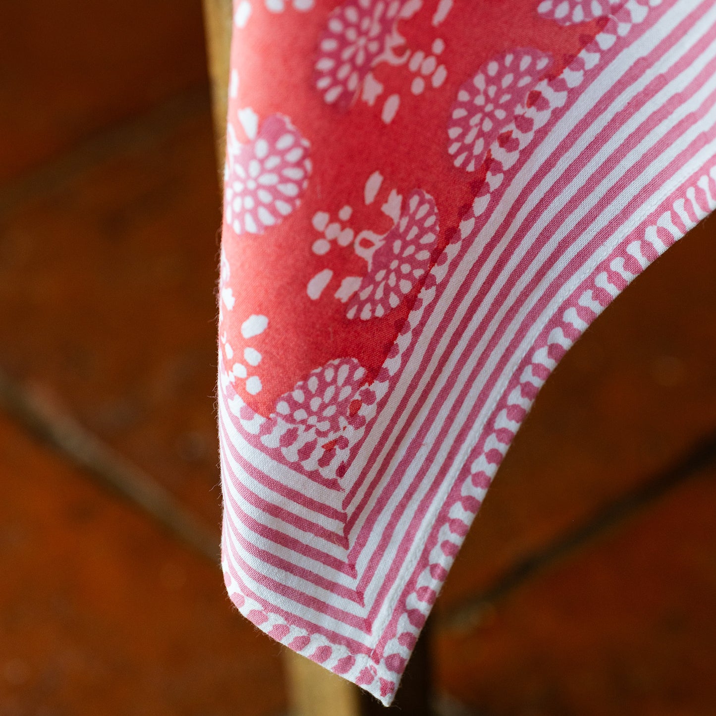 Close-up of a red and white patterned fabric on a wooden surface