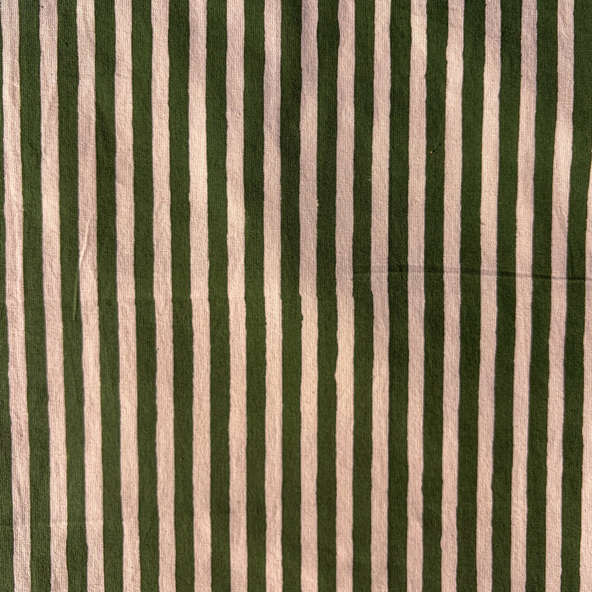 A close-up of a striped fabric pattern featuring alternating vertical stripes of dark forest green and a warm, dusty pink-beige.