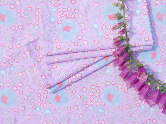 Purple flowers and patterned fabric with pink and white flowers on a light blue background.Napkins