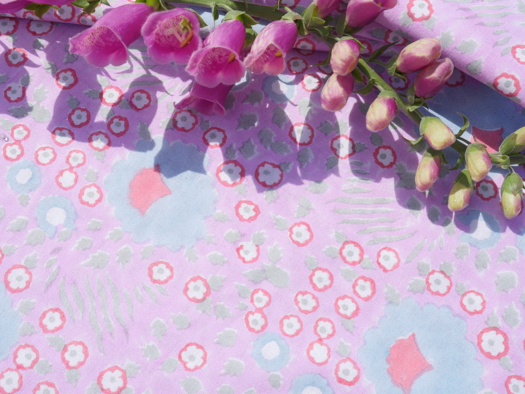 Floral fabric with pink flowers on a light purple background