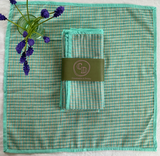 Green checkered napkin with a folded green checkered napkin and a visible brand label on a white background. gingham napkin
