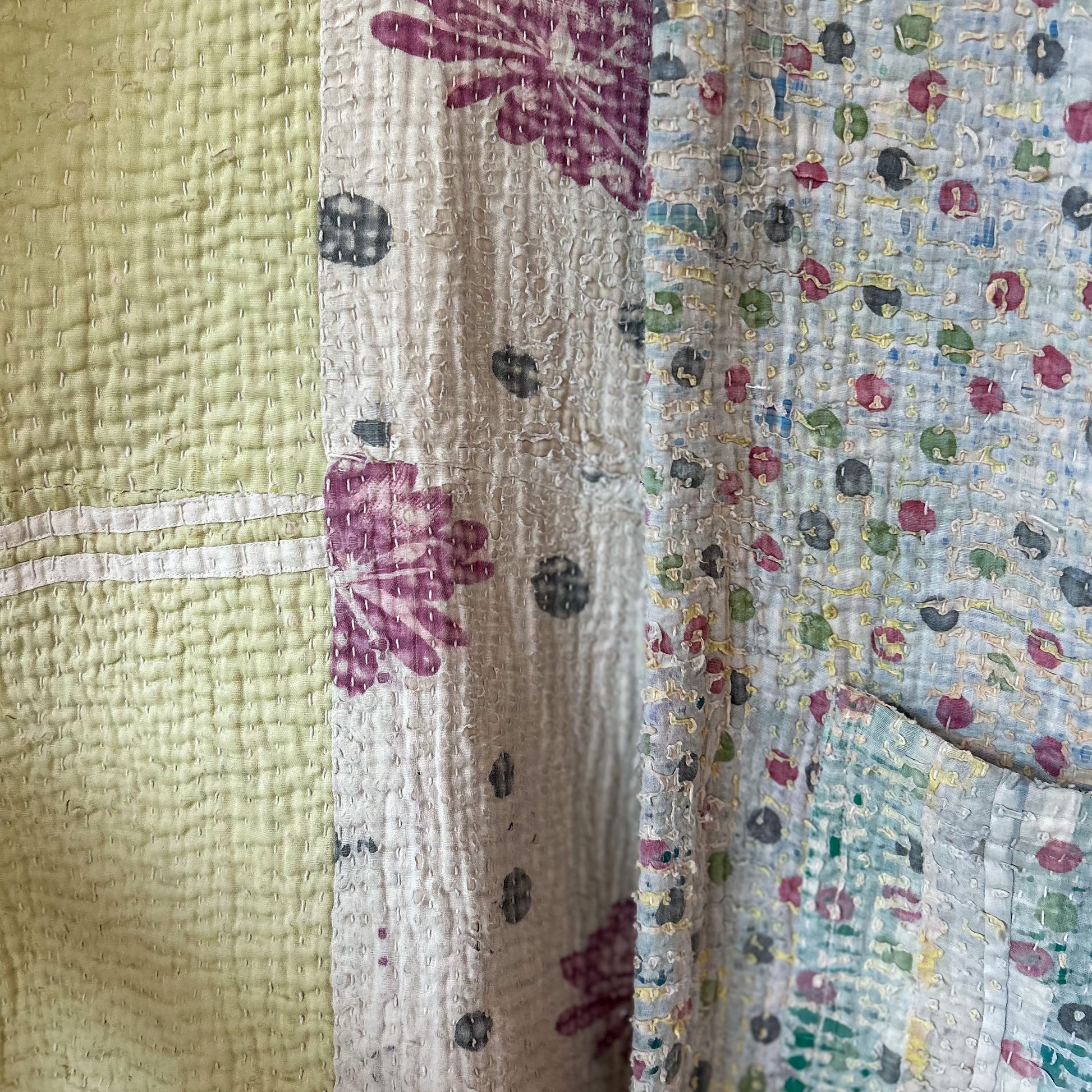 Close-up of a quilt with floral patterns in various colors. intage-kantha-jacket-handmade-unique-42-textured-detail