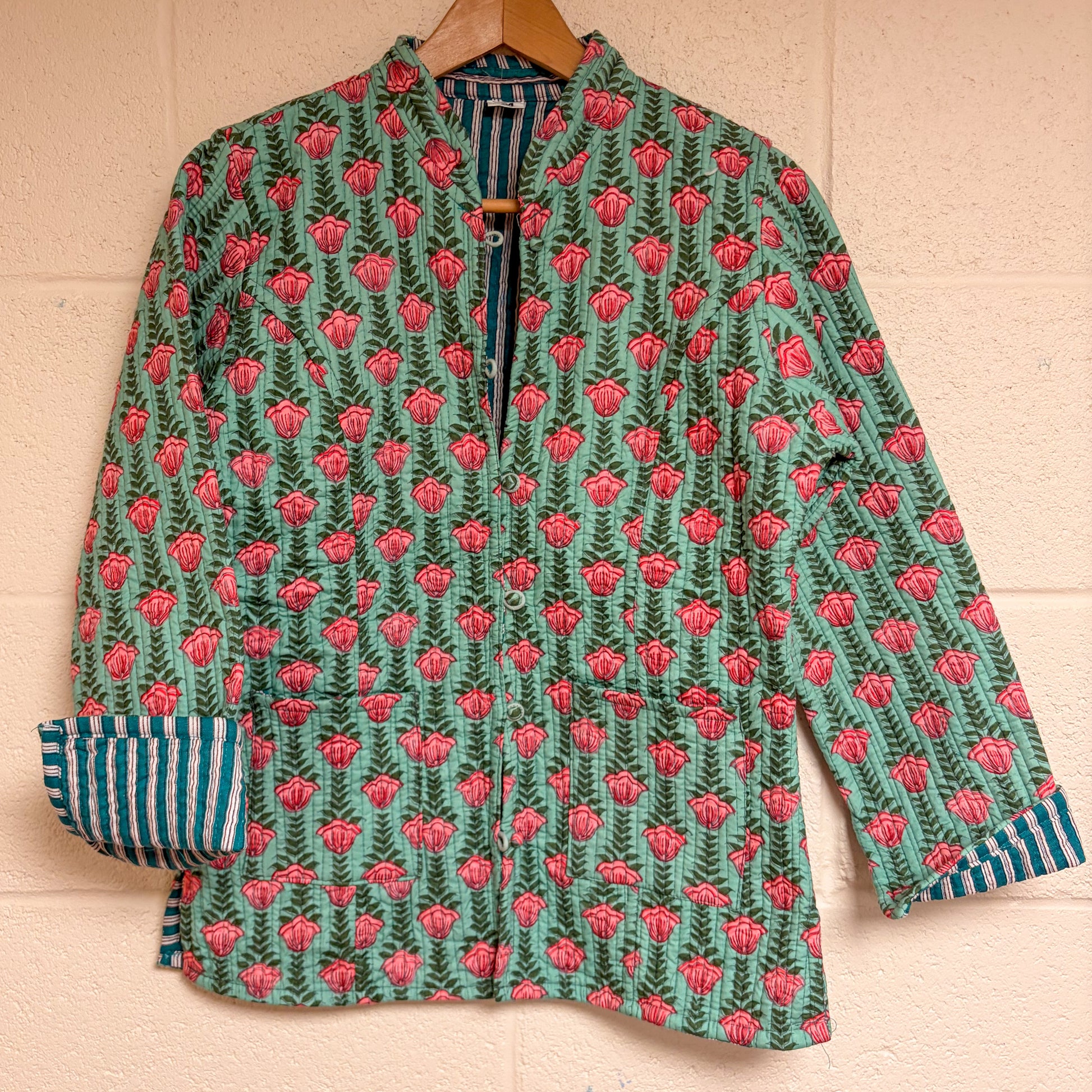 block printed jacket with pink floral pattern on a beige background
