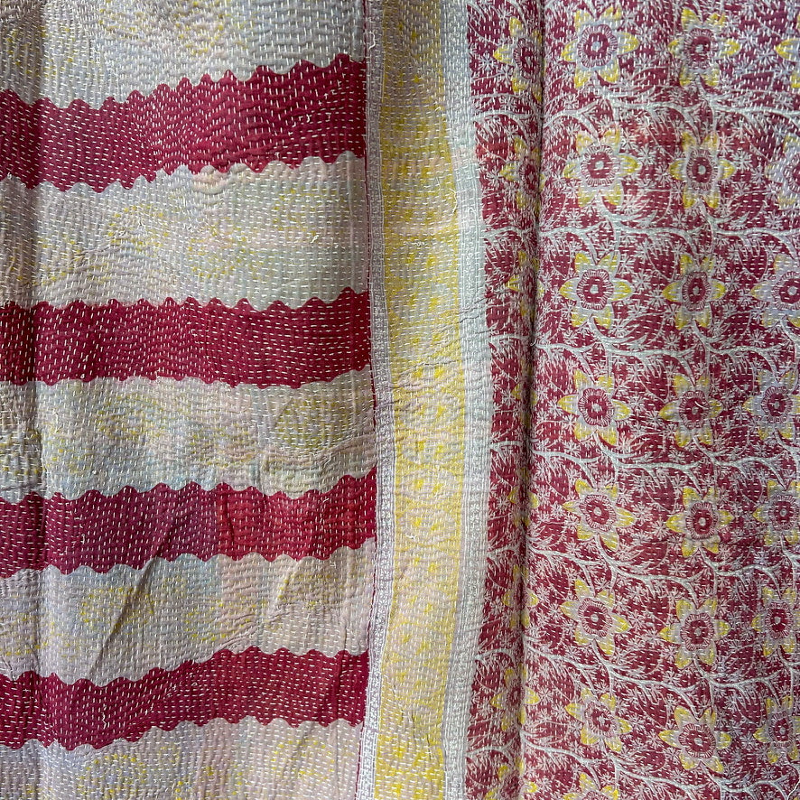 Close-up of fabric with red and white striped pattern, yellow stripe, and floral pattern.
