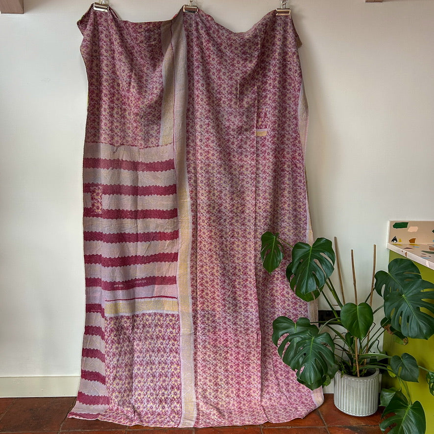 Patterned fabric draped over a chair with plants in the background