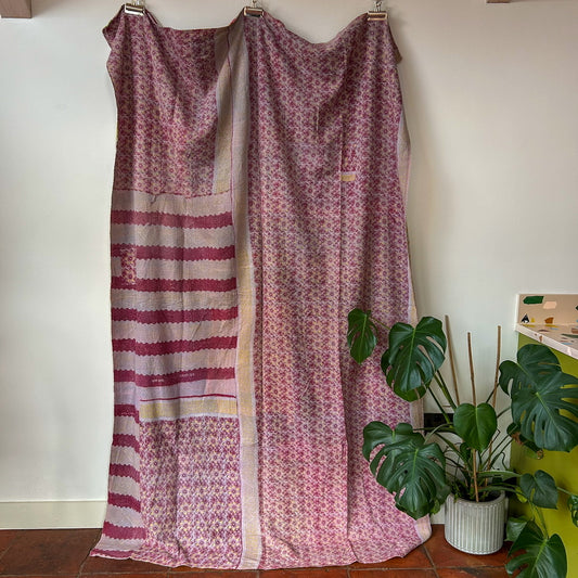Patterned fabric draped over a chair with plants in the background