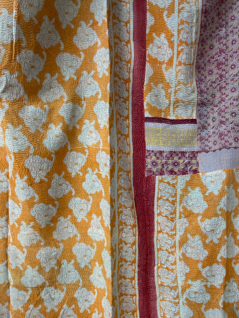 Close-up of patterned fabric with yellow and white floral design on a textured background
