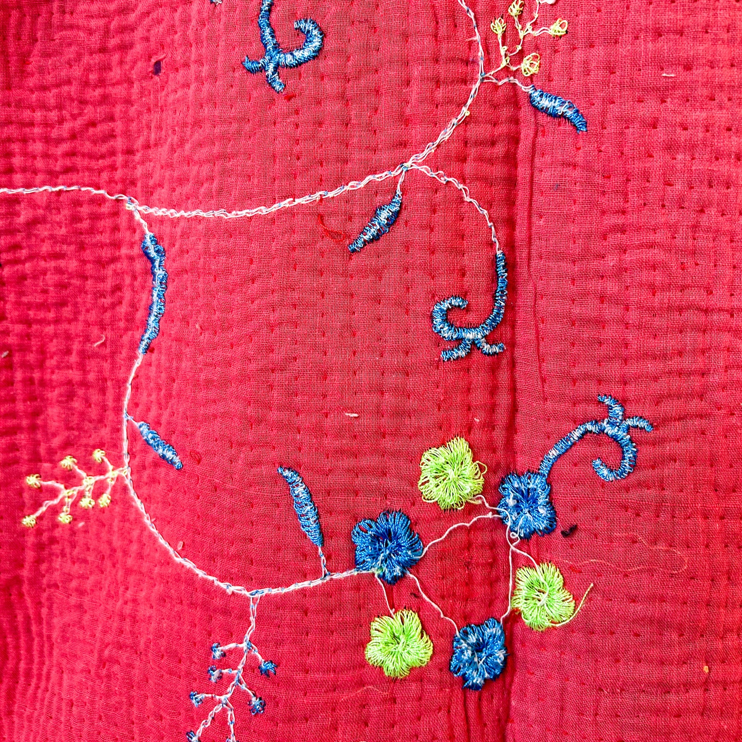 Close-up of embroidered flowers on a red fabric background