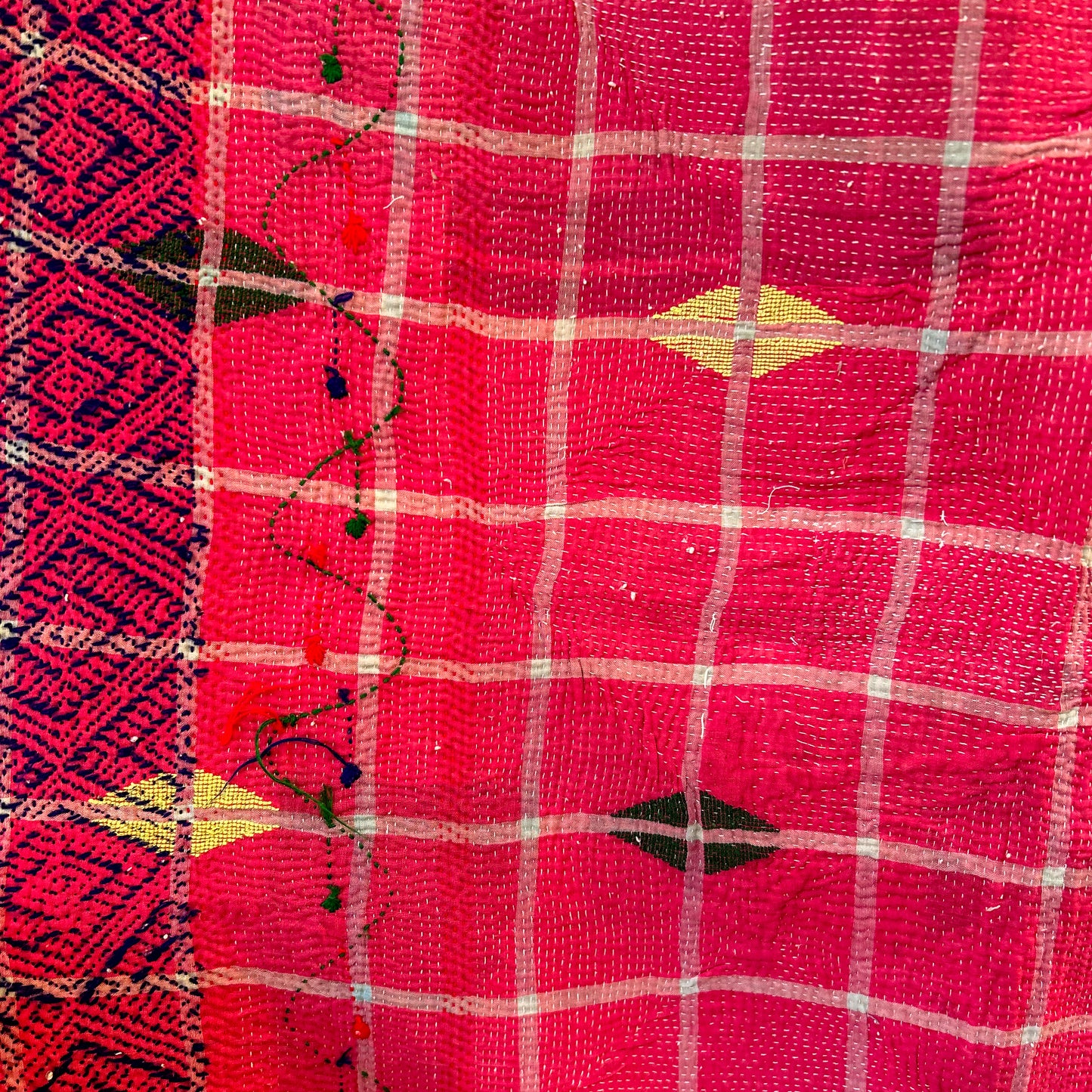 Close-up of a red fabric with white checkered pattern and decorative elements.