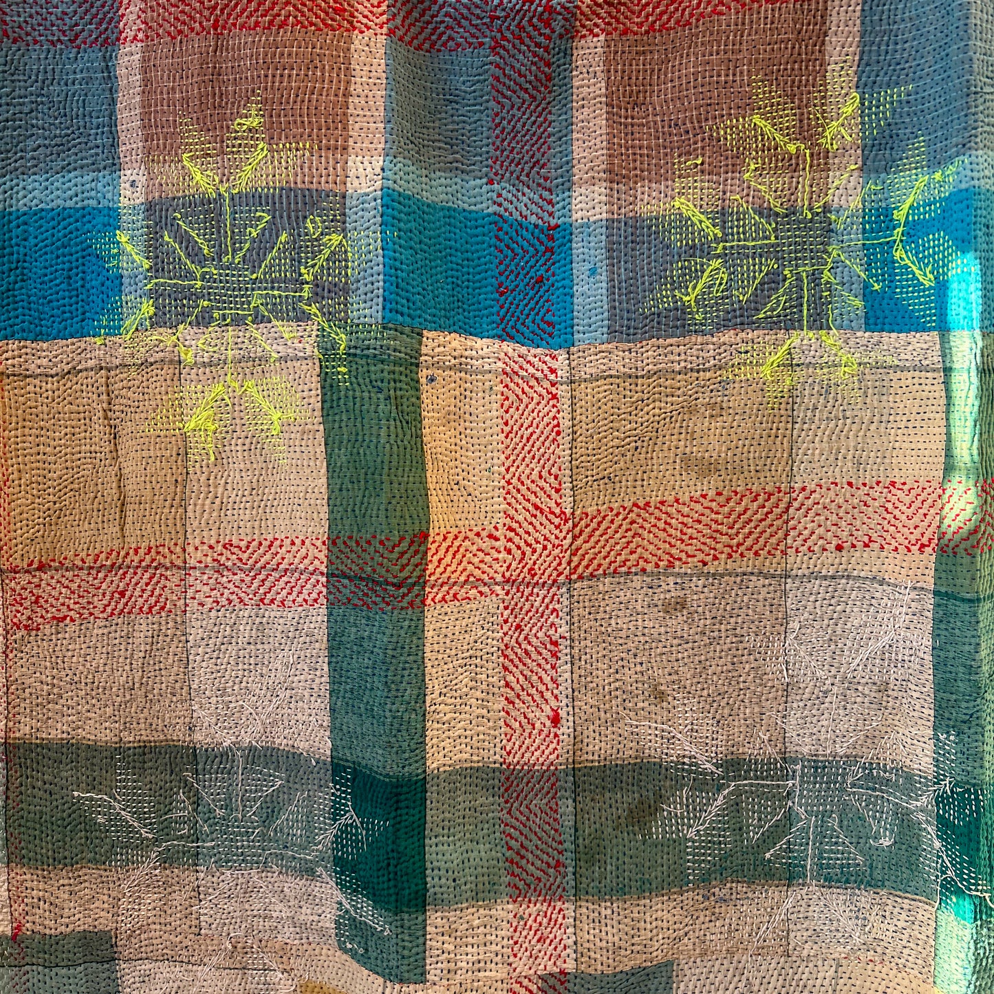 Close-up of a plaid fabric with blue, red, and beige colors.