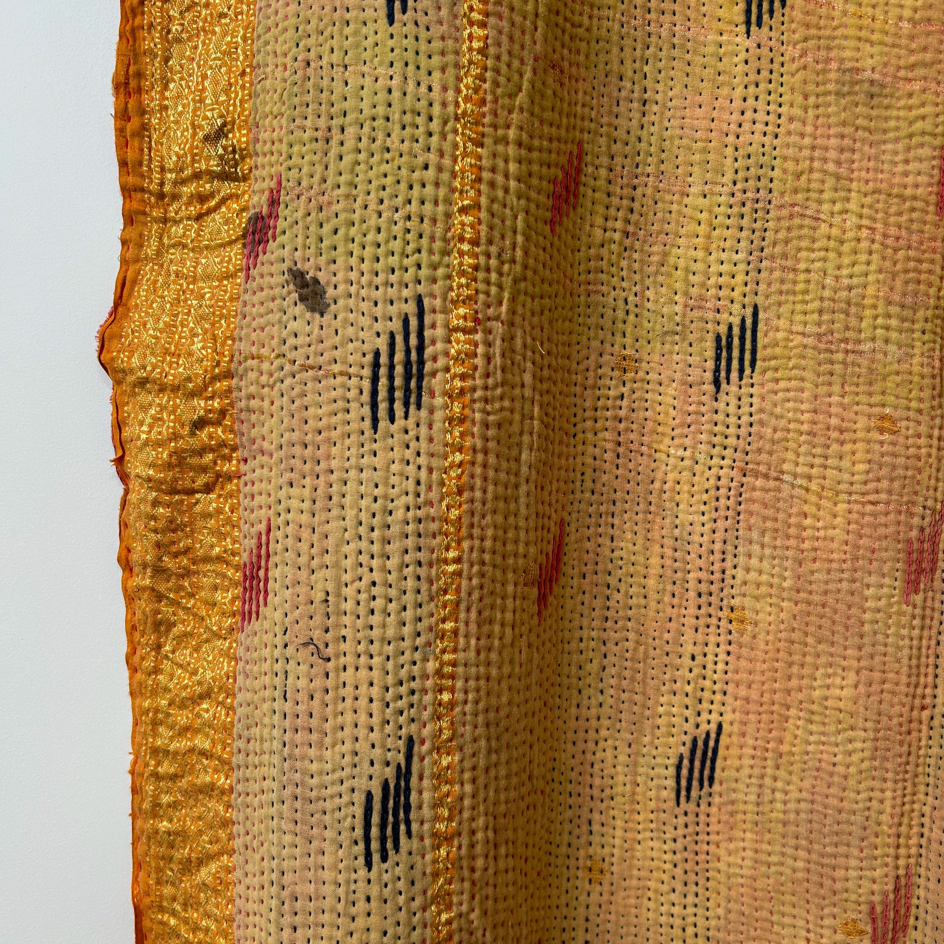 Close-up of textured fabric with gold border and patterned design. kantha-vintage-2025-hand-made-blanket-throw-textiles-wall-hanging