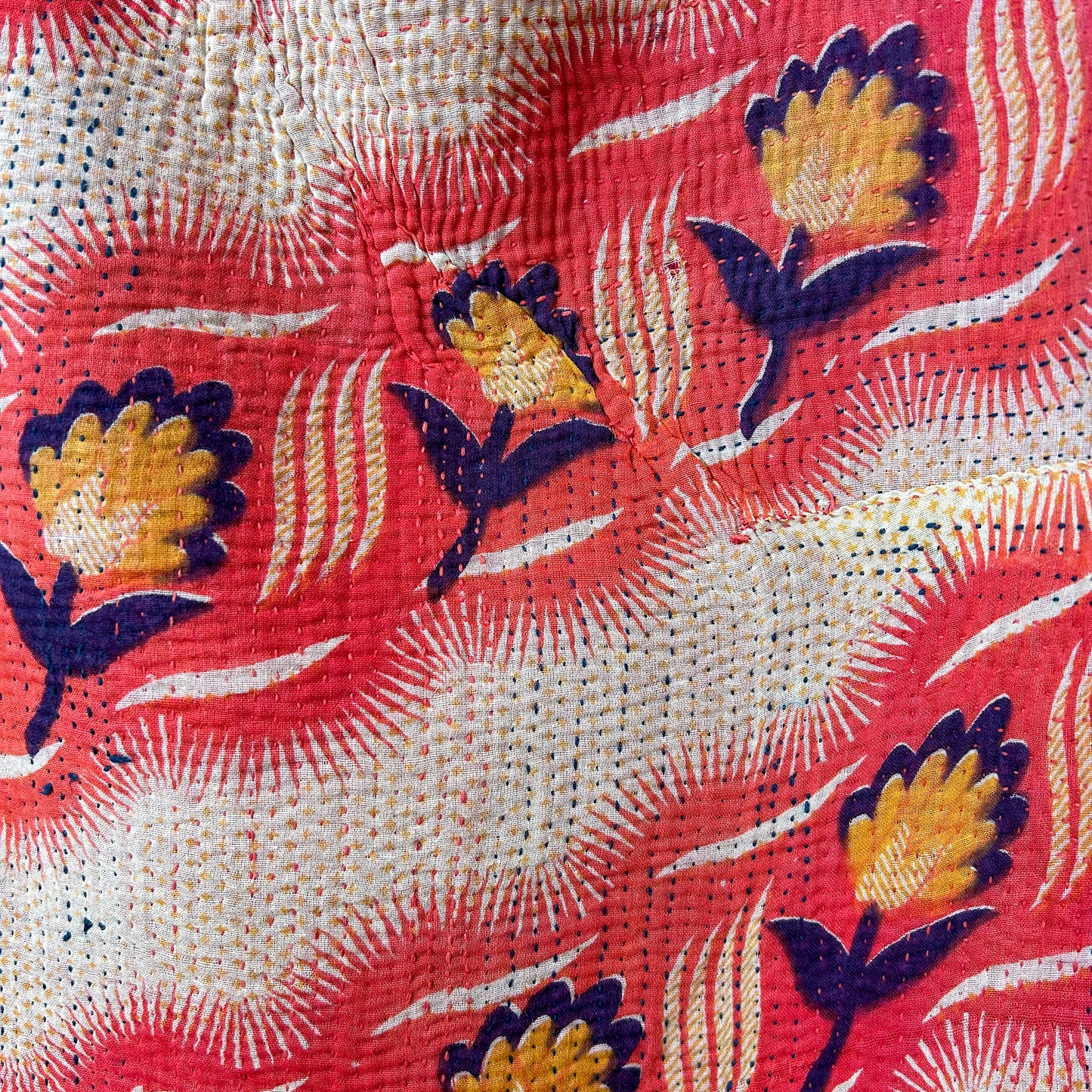 Close-up of a fabric with floral embroidery on a red background. kantha-vintage-2025-hand-made-blanket-throw-textiles-wall-hanging