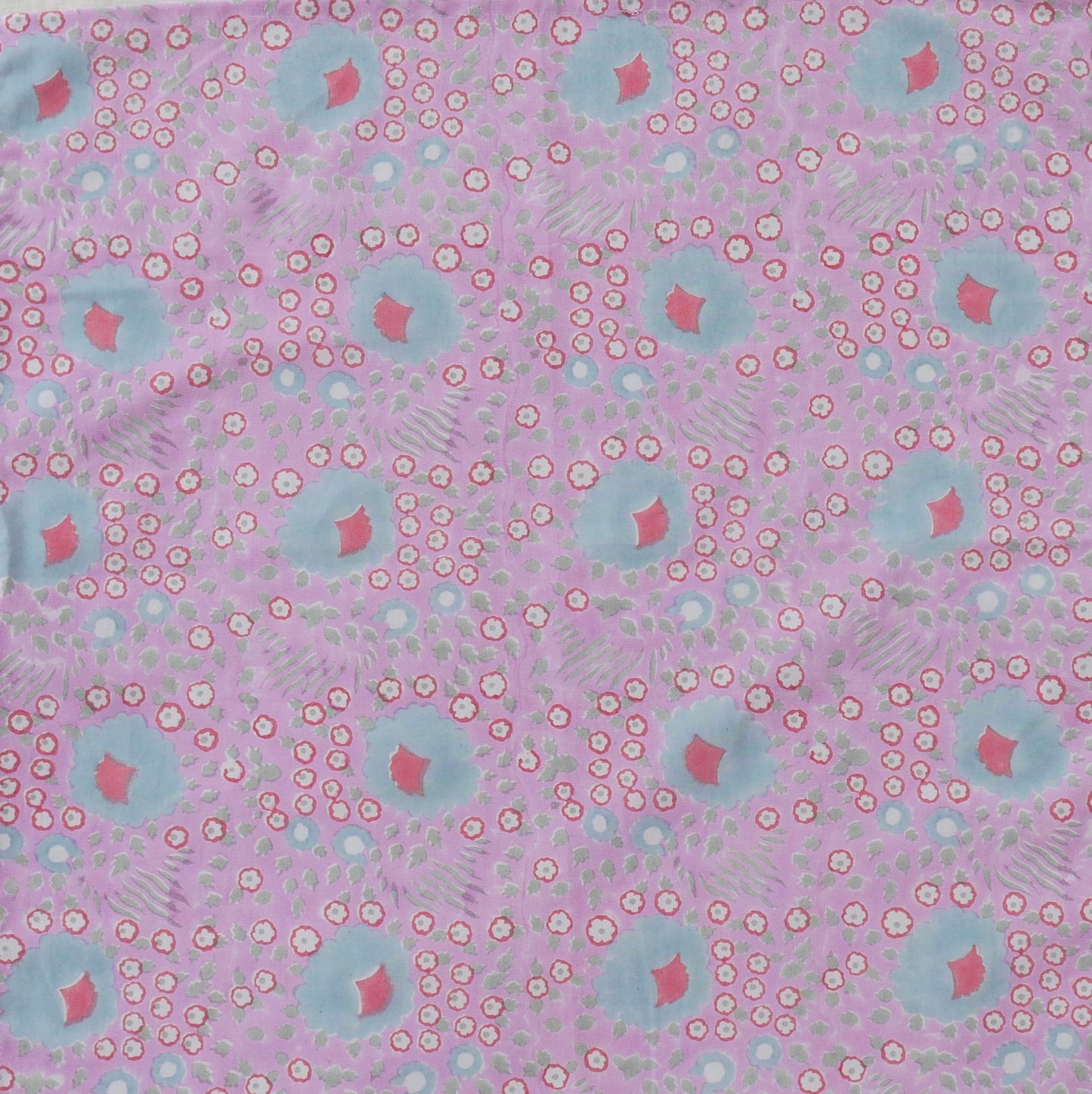 Patterned fabric with pink and blue shapes on a pink background