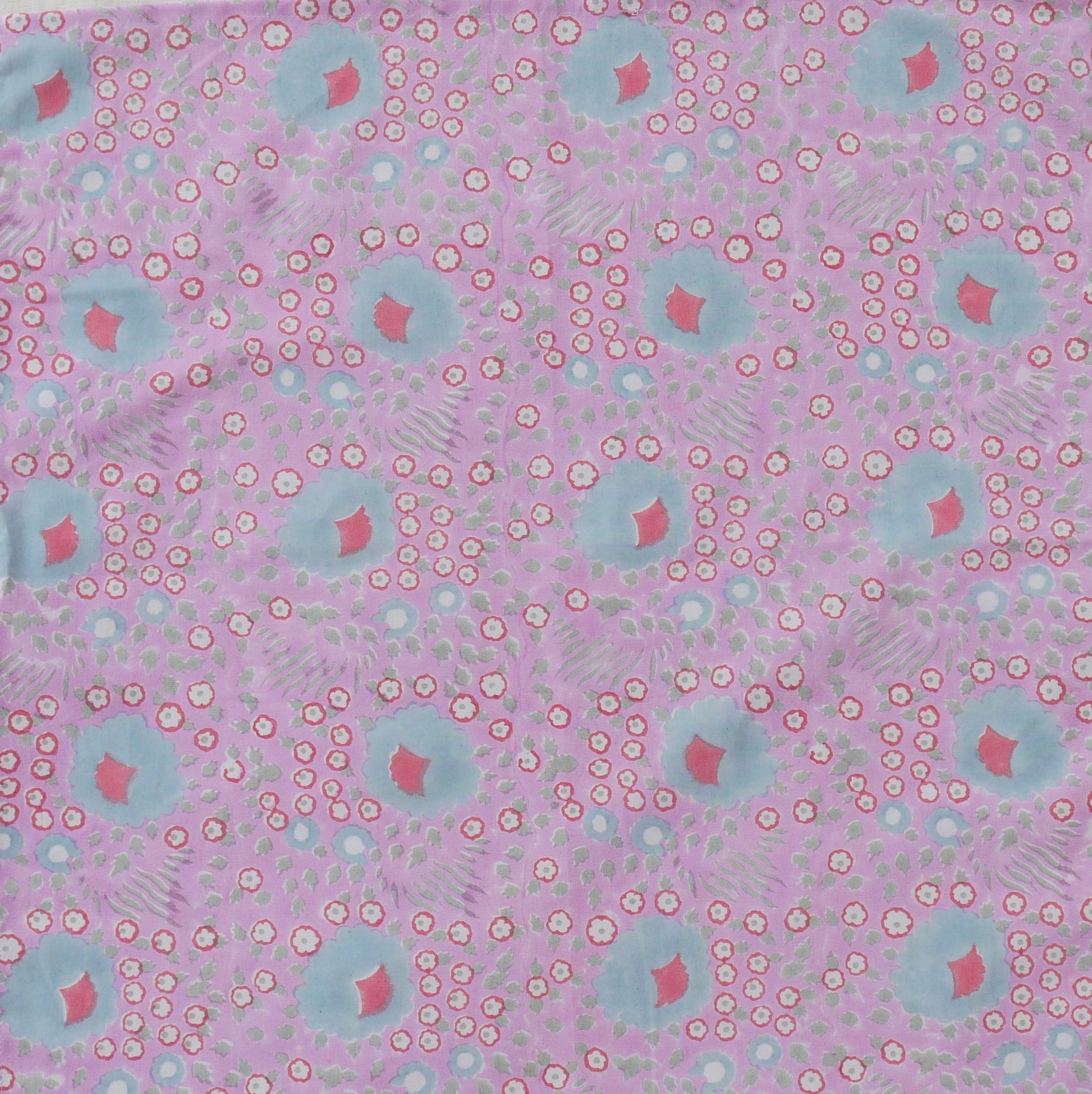Patterned fabric with pink and blue shapes on a pink background