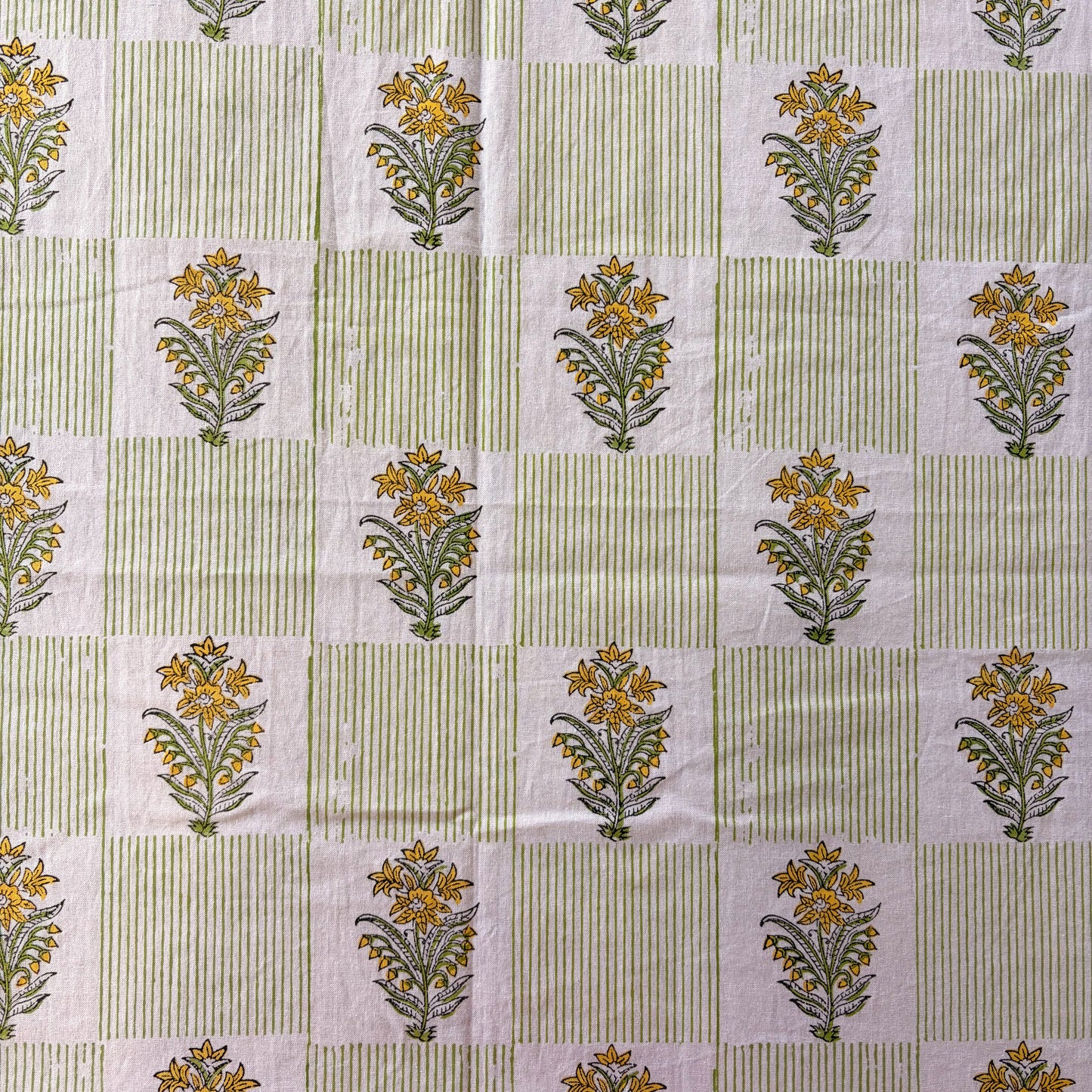 Patterned fabric with floral designs on a green and white striped background