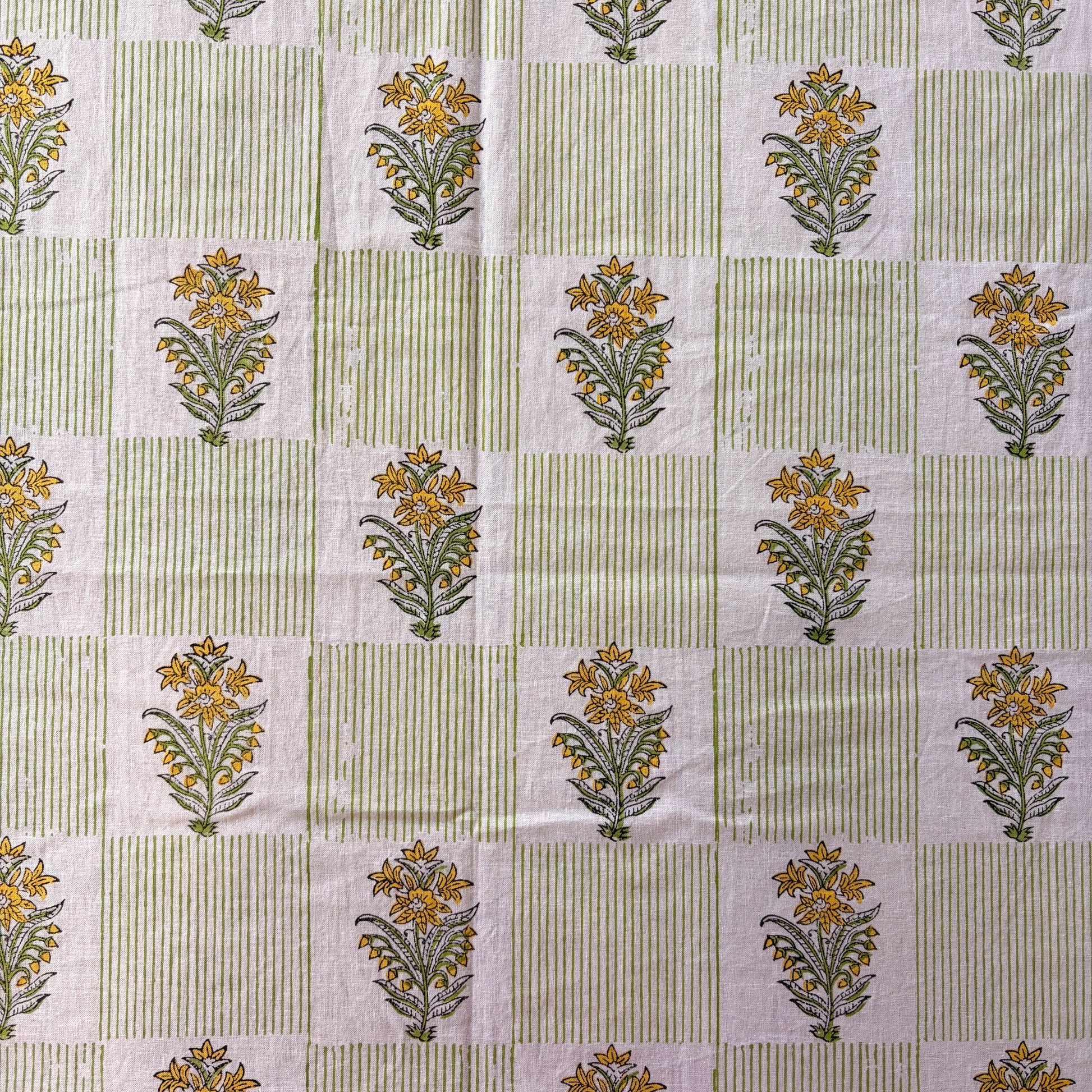 Patterned fabric with floral designs on a green and white striped background