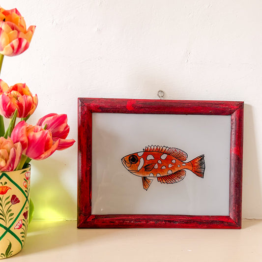 Framed artwork of a fish next to a vase with tulips on a white background. glass painting