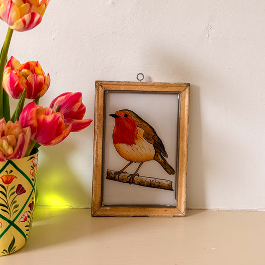 Framed illustration of a robin on a white background next to a vase of tulips.