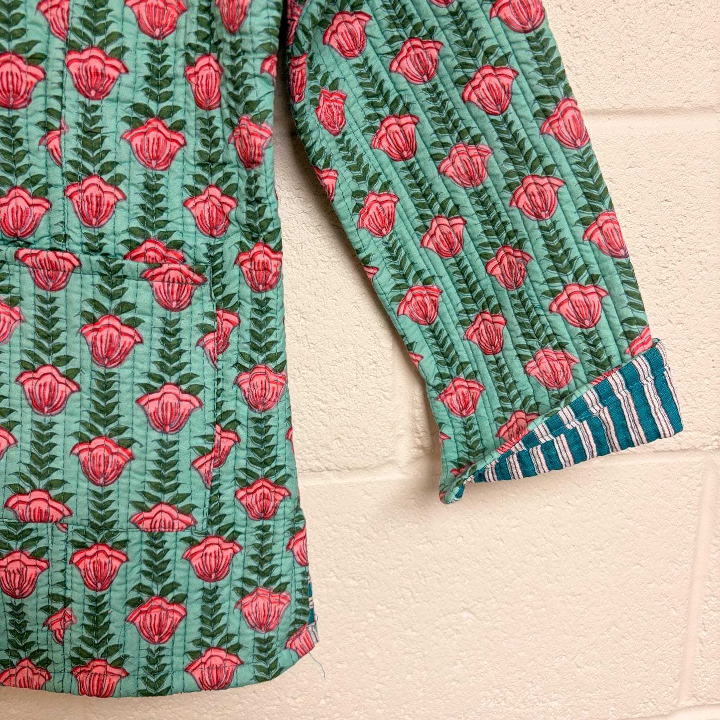 Green and red patterned fabric on a beige background