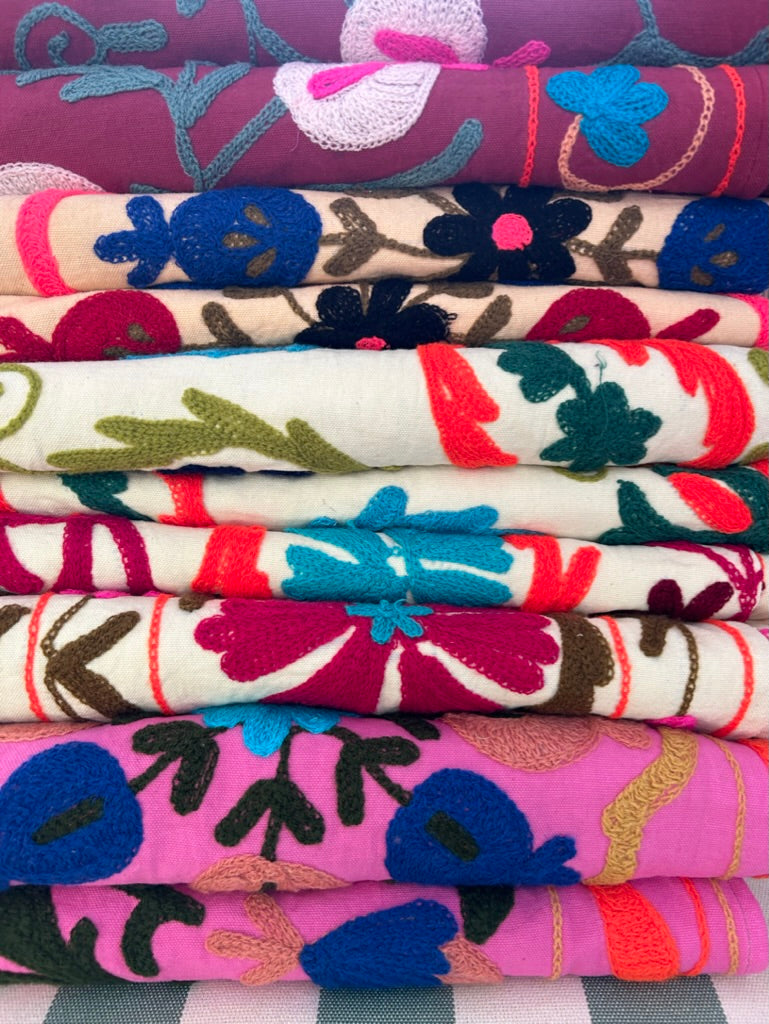 Stack of colorful fabric swatches with floral patterns