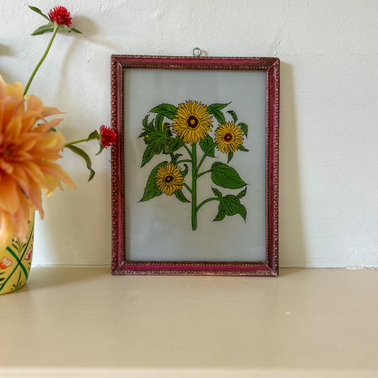 Framed embroidered artwork of sunflowers on a white surface with flowers in the background. constance-and-denny-indian-reverse-glass-painting-boxed-packaging-hand-painted-artisan-art