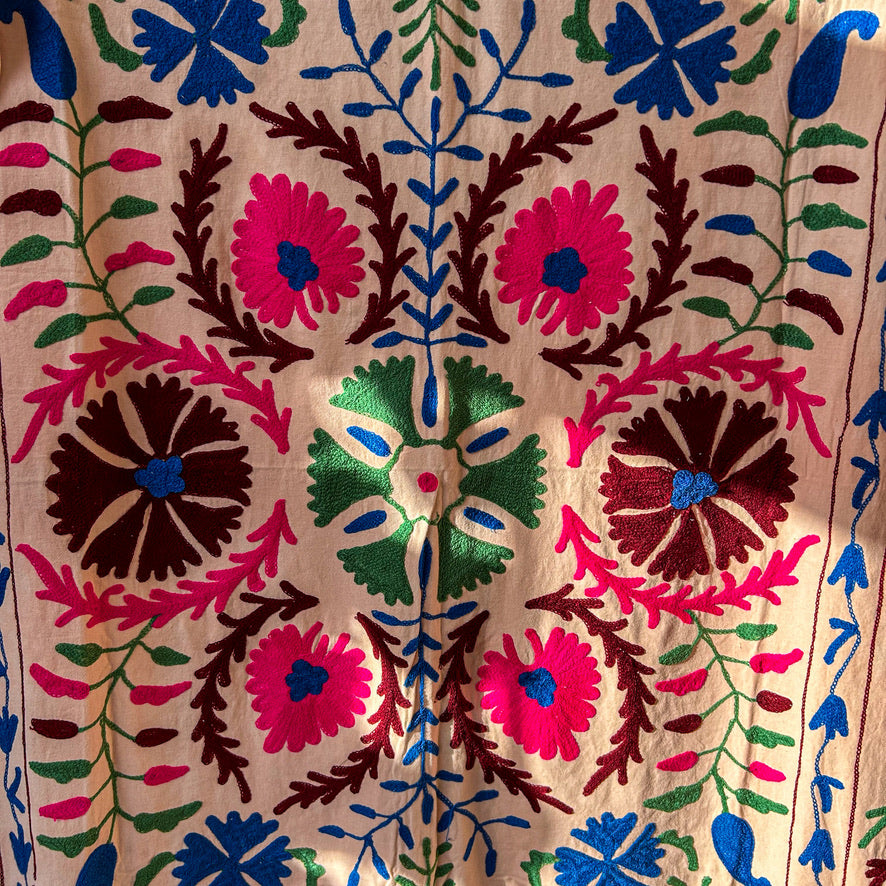 Close-up of a colorful floral embroidery pattern on fabric. blnket and wall -hanging